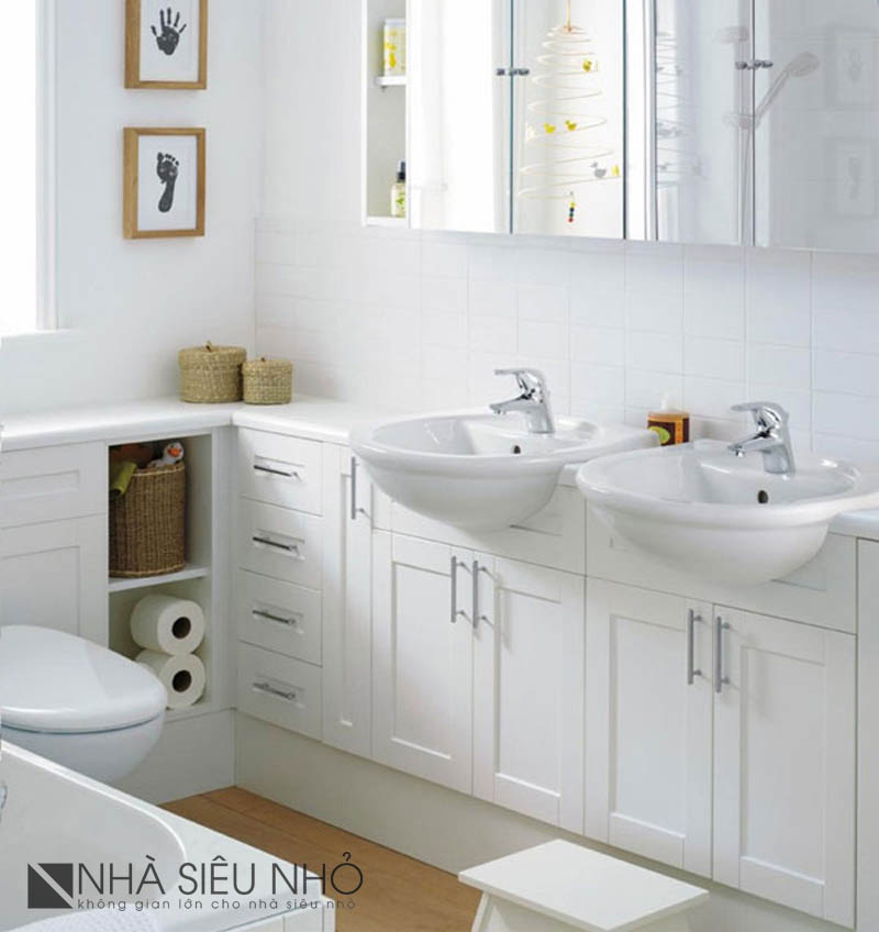 Phòng tắm nhỏ sử dụng gam màu trắng, Xung quanh tường chính là chiếc tủ gỗ thấp, kiêm bệ đỡ bồn rửa mặt. Phía trên là tủ gương để đồ